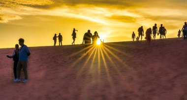 Kumsalda sırt çantalı bir çiftin silueti.