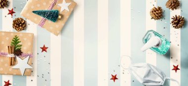 Noel hediye kutuları, bir maske ve yukarıdan bir dezenfektan şişesi.