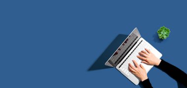 Yukarıdan dizüstü bilgisayar kullanan kişi