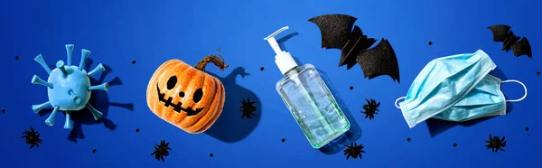 Masks and sanitizer bottle with Halloween objects - healthcare and hygiene concept