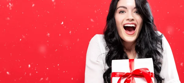 Glad Ung Kvinna Som Håller Julklapp Låda Röd Bakgrund — Stockfoto