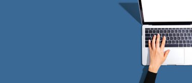 Yukarıdan dizüstü bilgisayar kullanan kişi