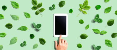 Tablet bilgisayarlı yeşil yapraklar - düz yatıyordu