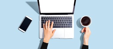 Yukarıdan dizüstü bilgisayar kullanan kişi