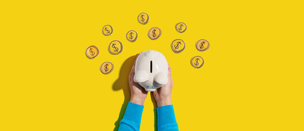Person holding a piggy bank with hand drawn coins