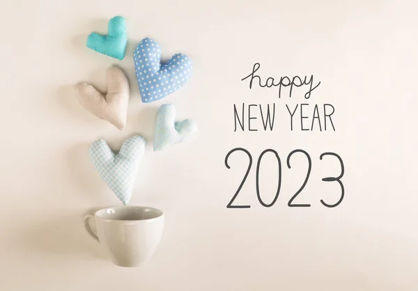 コーヒーカップから出てくる青いハートクッションと新年2023メッセージ — ストック写真