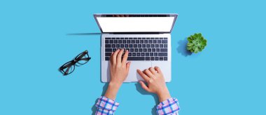 Yukarıdan dizüstü bilgisayar kullanan kişi