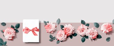 Üstünde pembe güller olan bir hediye kutusu. Düz yatıyordu.