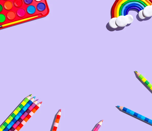 Art supplies with a rainbow - overhead view - flat lay