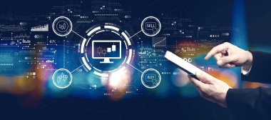 Stock trading theme with businessman using a tablet computer at night