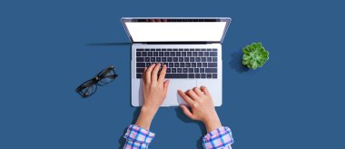 Yukarıdan dizüstü bilgisayar kullanan kişi