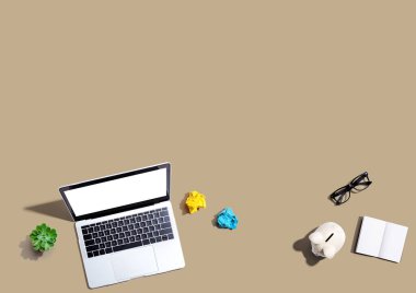 Domuz kumbarası ve ofis eşyalarıyla dizüstü bilgisayar - düz konum