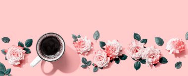 Üzerinde pembe güller olan kahve, düz bir şekilde yatıyordu.