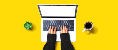 Yukarıdan dizüstü bilgisayar kullanan kişi