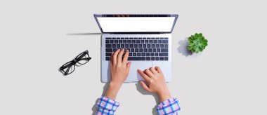 Yukarıdan dizüstü bilgisayar kullanan kişi