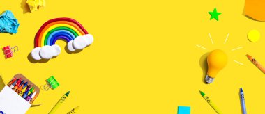 Gökkuşağı ve okul gereçleri manzaralı bir ampul.