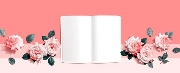 stock image White blank notebook with pink roses overhead view - flat lay