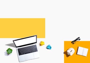 Domuz kumbarası ve ofis eşyalarıyla dizüstü bilgisayar - düz konum