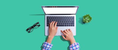 Yukarıdan dizüstü bilgisayar kullanan kişi