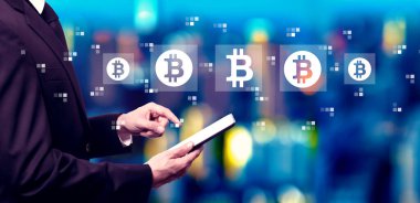 Bitcoin theme with businessman using a tablet computer at night