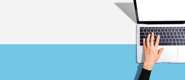 Yukarıdan dizüstü bilgisayar kullanan kişi