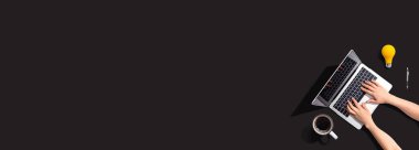 Yukarıdan dizüstü bilgisayar kullanan kişi