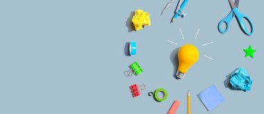 Idea light bulb with school supplies overhead view - flat lay