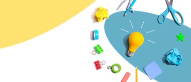 Idea light bulb with school supplies overhead view - flat lay