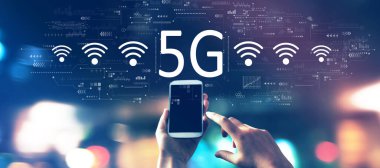Gece bulanık şehir ışıklarında akıllı telefonlu 5G ağı