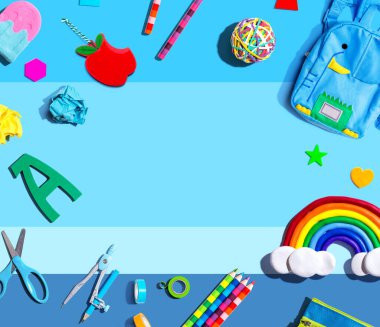 School supplies with a rainbow - overhead view - flat lay