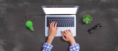 Dizüstü bilgisayarı olan yeşil ampul - düz yatıyordu