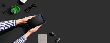 Yukarıdan tablet bilgisayar kullanan bir kadın