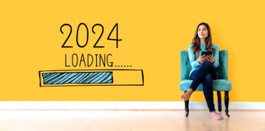 Yeni yıl 2024 'ü elinde tablet bilgisayarla genç bir bayanla doldurmak