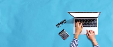 Yukarıdan dizüstü bilgisayar kullanan kişi