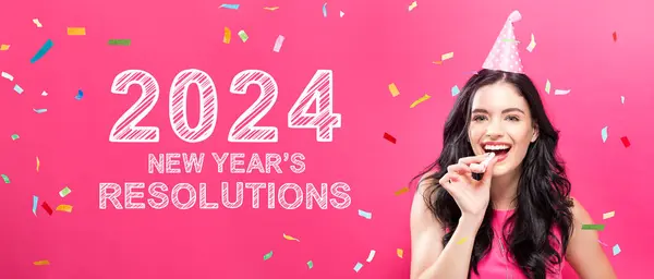 2024 ピンクの背景にパーティーをテーマにした若い女性との新年の決議 ストック画像