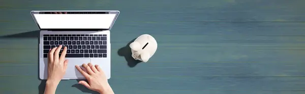 Laptop computer with piggy bank - flat lay
