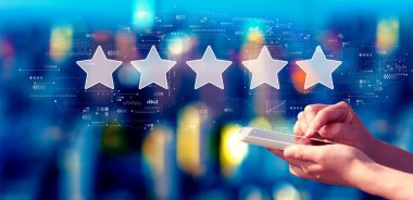 Rating star concept with person using a smartphone in a city at night