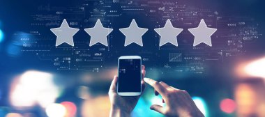 Gece bulanık şehir ışıklarında akıllı telefonlu yıldız konsepti