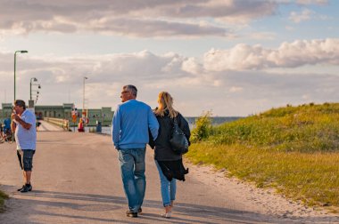 Günbatımında Malmö 'deki Ribban plajında yürüyen çift.