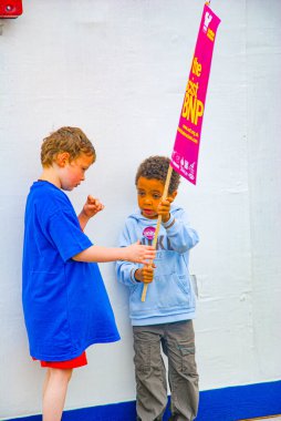 LONDON, UK, 21 June 2008: Two kids are playing with a sign with the message smash the BNP clipart