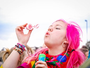 MALMO, SWEDEN, 19 Eylül 2008: Gökkuşağı kıyafetleri içinde pembe saçlı aktivist kız sabun köpükleri üflüyor