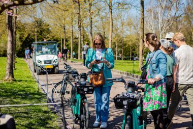 Danimarka 'nın Kopenhag kentindeki Bispegjerg mezarlığındaki kiraz ağacını ziyaret eden insanlar.