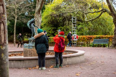 İsveç 'in Malmö kentindeki parkta heykel fotoğraflayan kadınlar