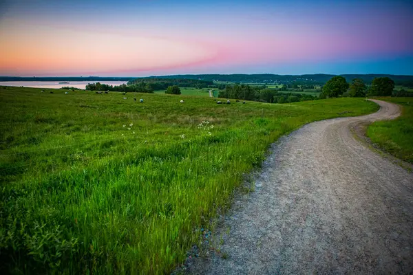 İsveç, Hassleholm 'deki Hovdala Hills' te çakıllı yolda gün batımı.