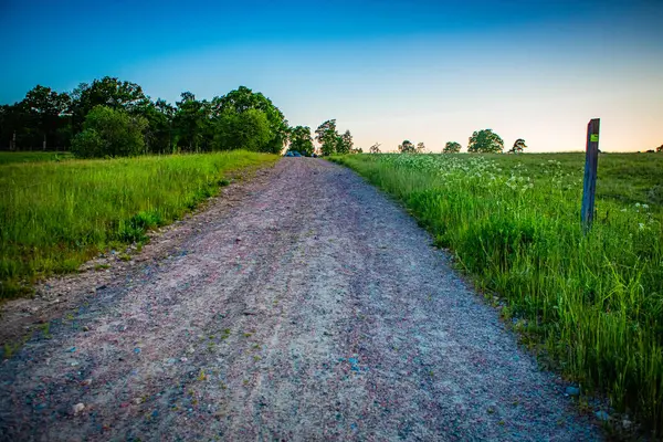 İsveç, Hassleholm 'deki Hovdala Hills' te çakıllı yolda gün batımı.