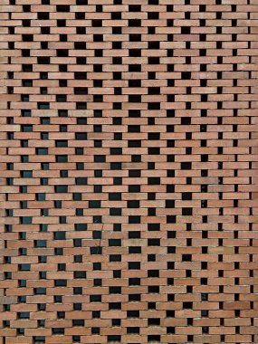  Karmaşık bir açılış şablonuna sahip modern bir mimari tuğla duvar büyüleyici bir ışık ve gölge oyunu ve eşsiz dokulu bir arka plan yaratıyor..