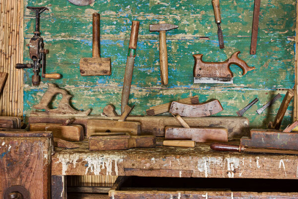 Woodworking hand tools of an old carpentry shop. Old craftsman workshop bench with carpenter equipment