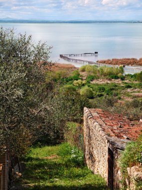 Lake Trasimeno, Perugia, Umbria, Italy: view from the village San Savino of the picturesque coast and the body of water with a long walkway clipart