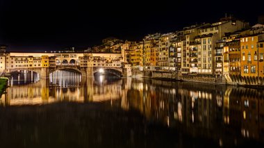 Floransa, Toskana, İtalya: Arno Nehri üzerindeki ünlü ortaçağ köprüsü Ponte Vecchio 'nun gece manzarası