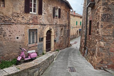 Sarteano, Siena, Tuscany, İtalya: Pembe Vespa scooter 'ı olan eski şehrin pitoresk antik sokağı. - Nisan, 7, 2019